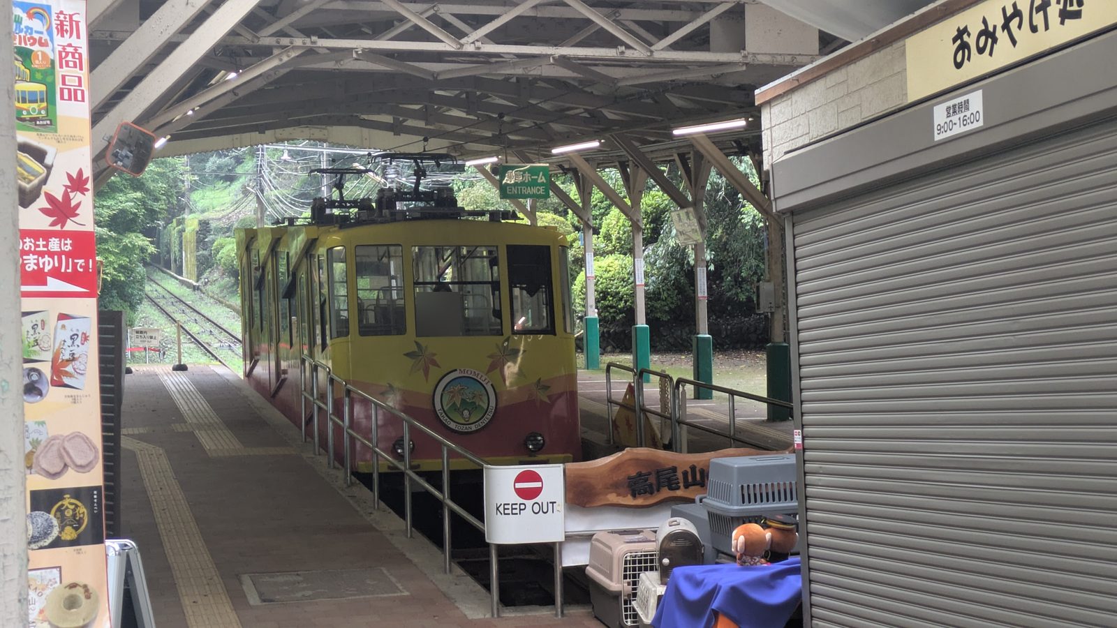 A yellow and maroon cable car waiting at the lower station platform