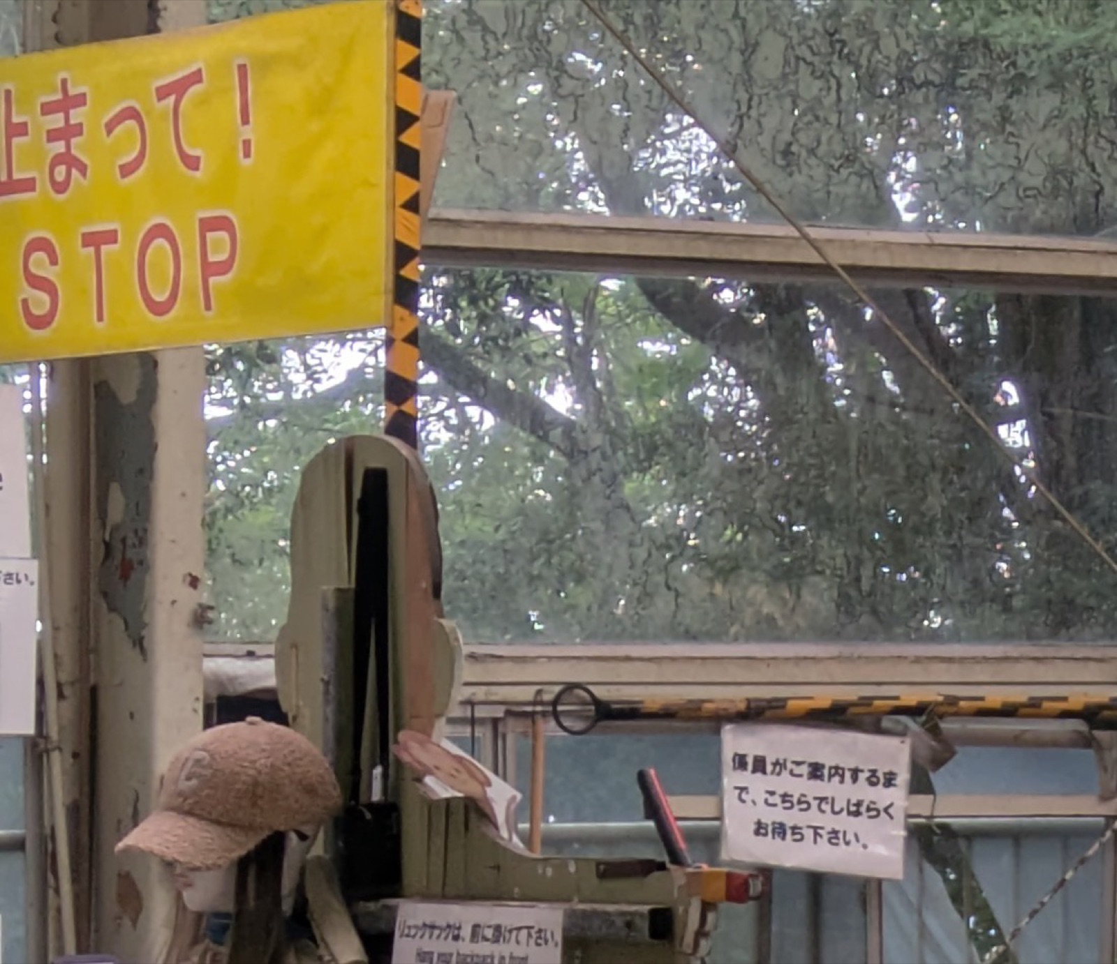 Signs at the Mount Takao chairlift boarding area, a yellow banner reading STOP beside a handwritten paper sign in Japanese