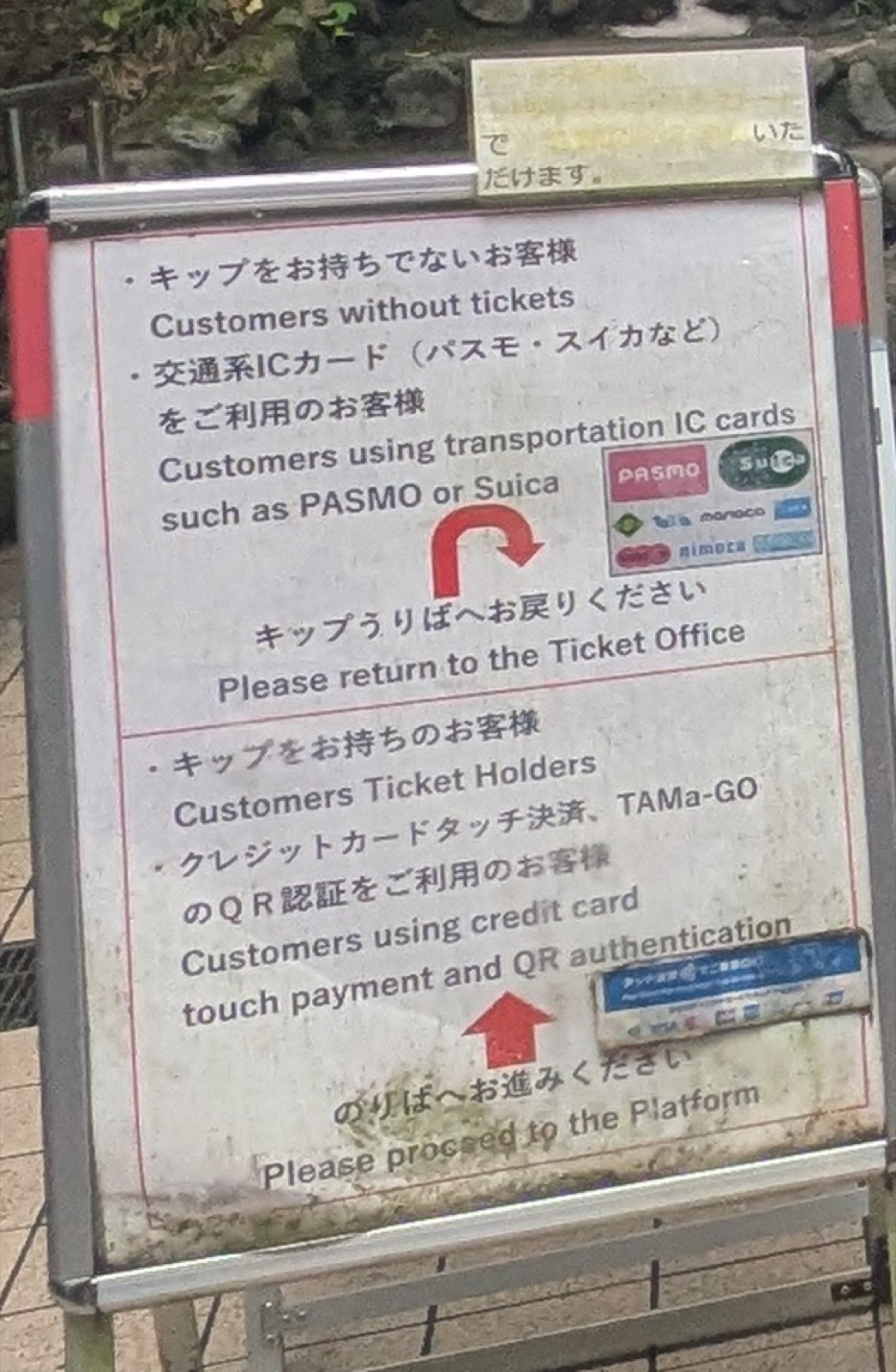 A bilingual standing sign at Mount Takao telling IC card users to return to the ticket office while contactless card users proceed to the platform