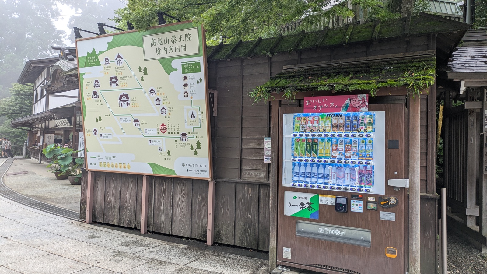 The temple's quadrilingual grounds map beside a vending machine inside Yakuo-in