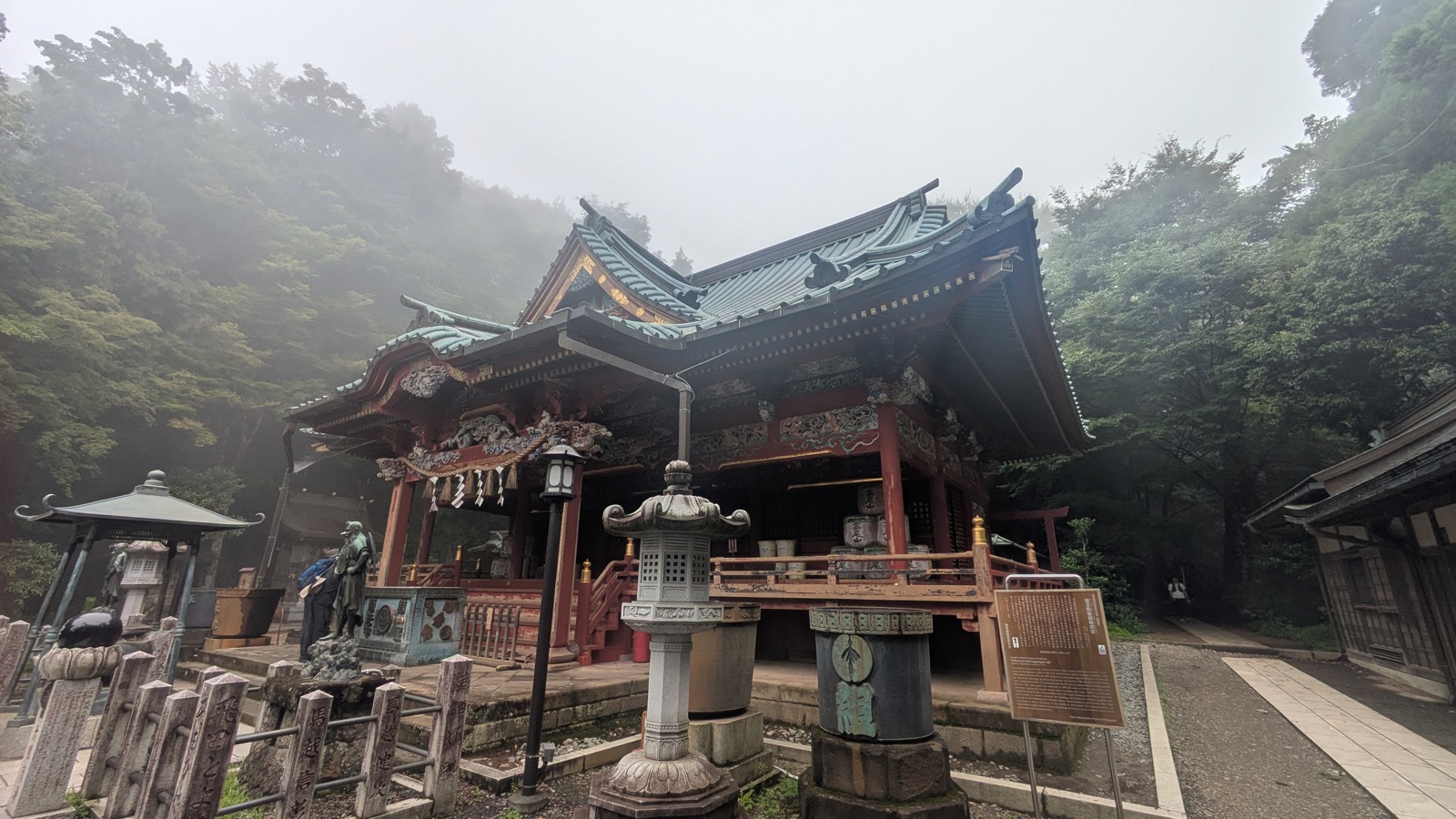 The ornate Izunagongendo Hall at Yakuo-in, painted red with green trim, covered in carvings