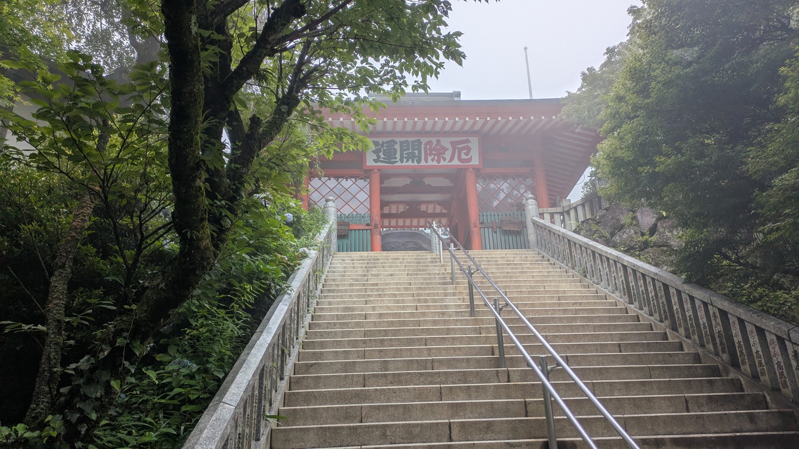 The vermilion Niomon Gate at Yakuo-in at the top of a long stone staircase