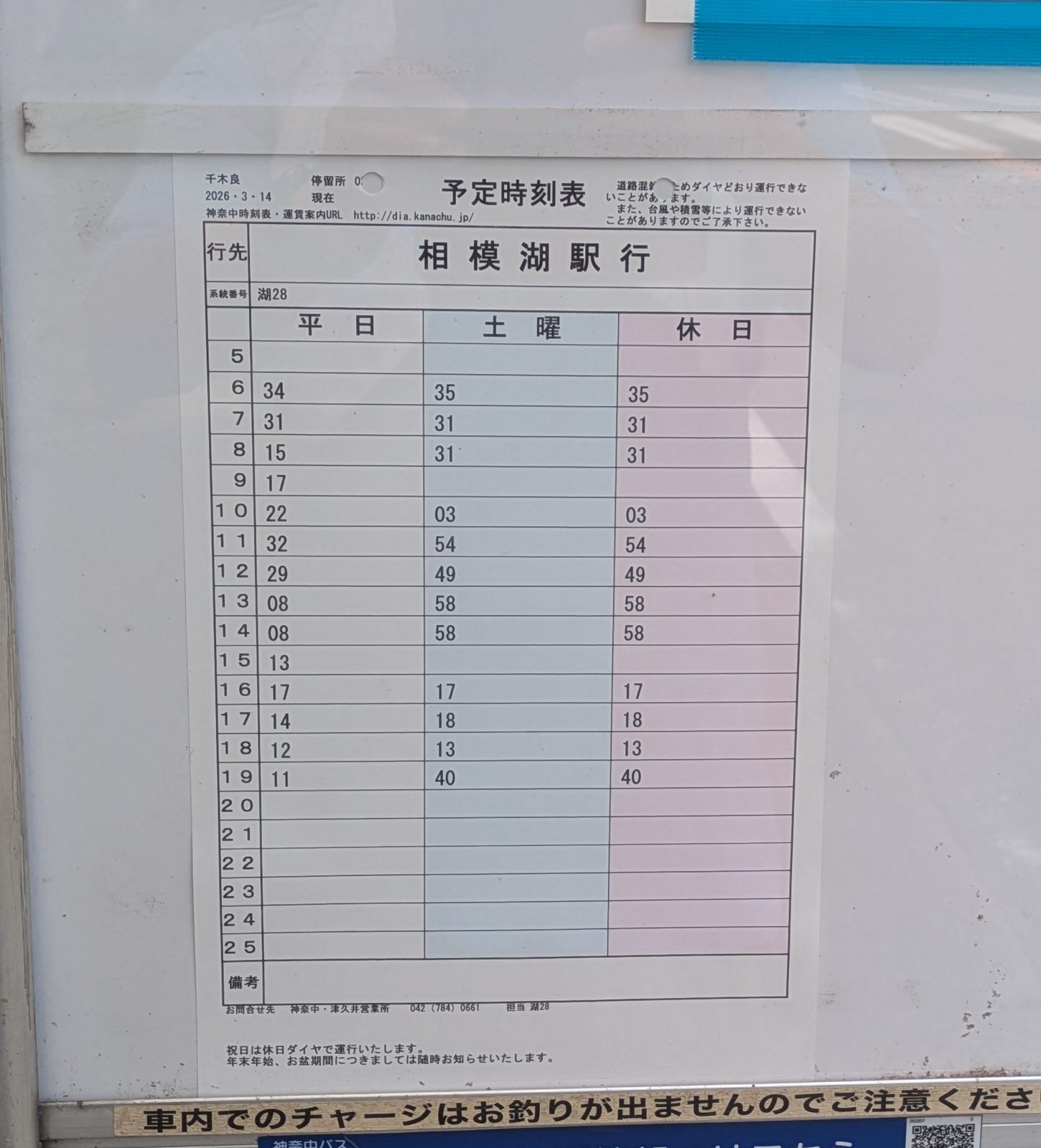 A bus stop timetable board with three columns of departure times in Japanese