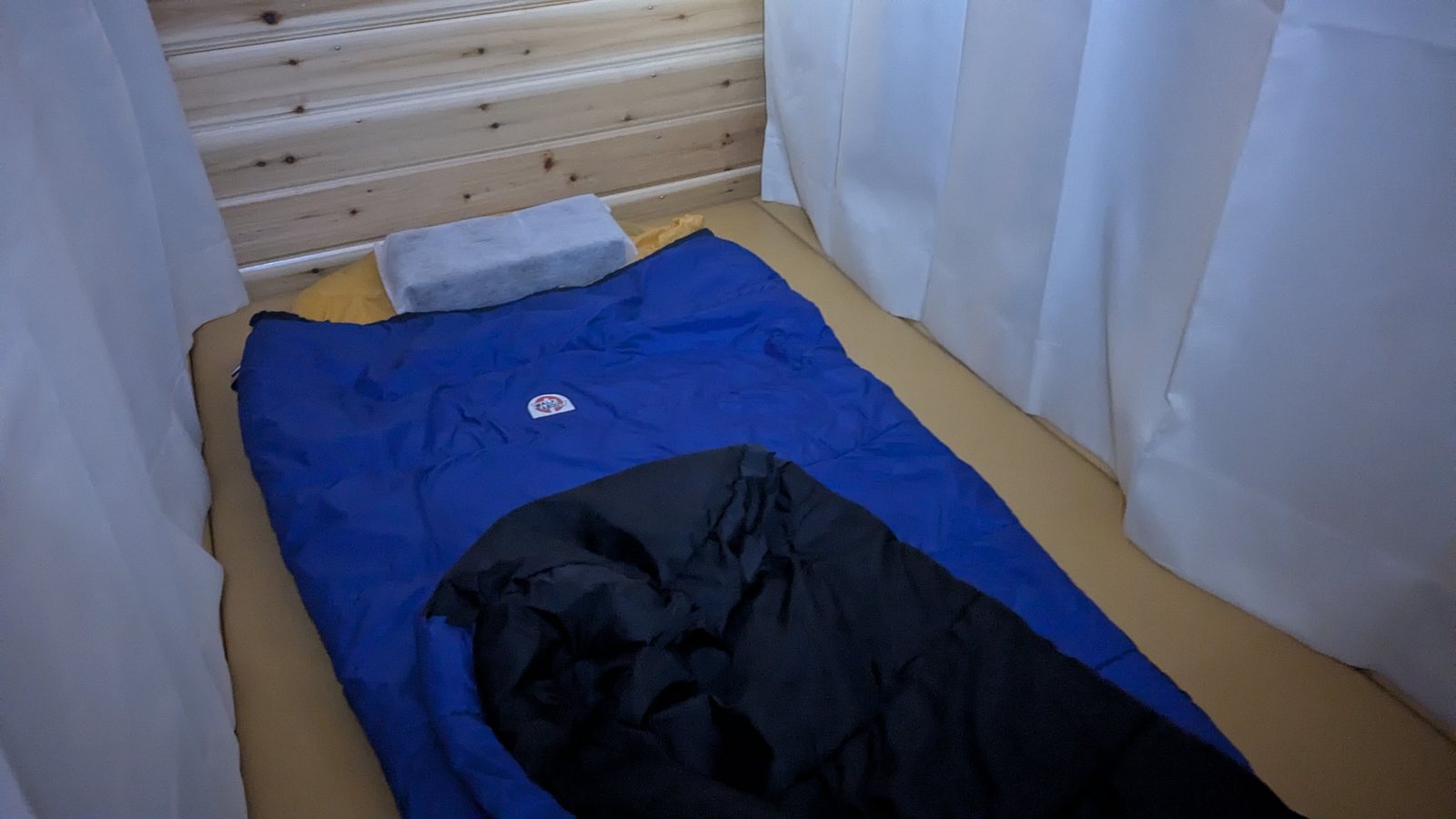 A single curtained sleeping berth in a mountain hut on Mount Fuji