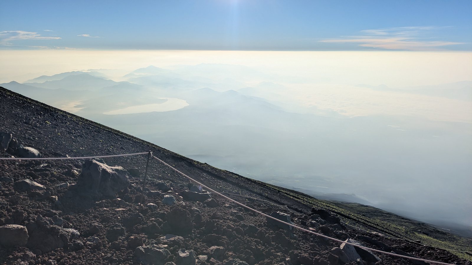 A rope fence on a volcanic slope above cloud on the Shizuoka side