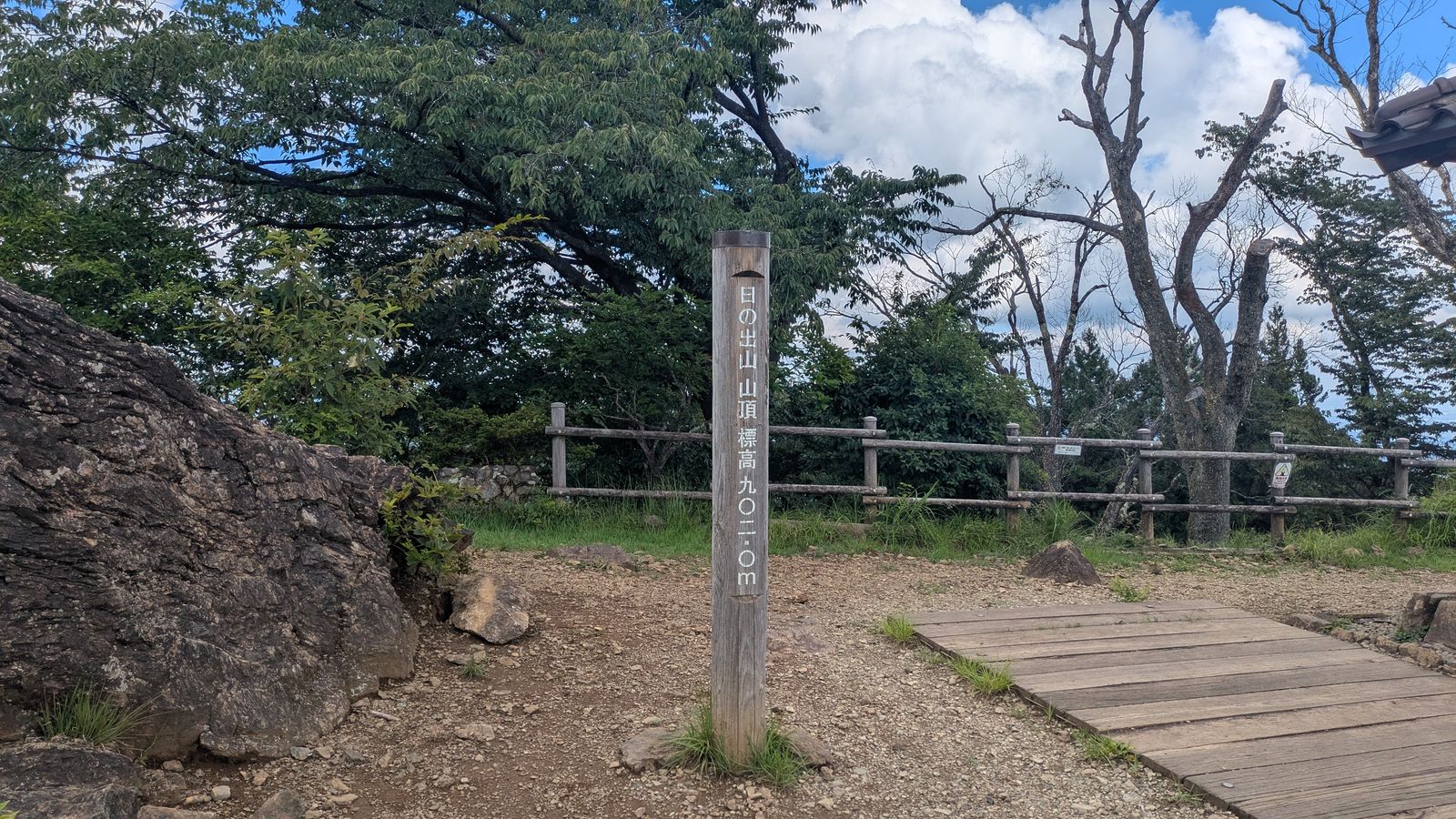A wooden summit post reading Mount Hinode 902.0 metres in Japanese