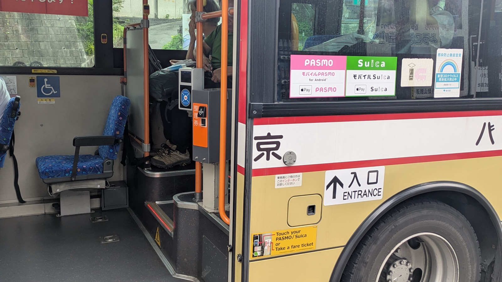 A ticket dispenser beside a card reader inside the middle door of a bus