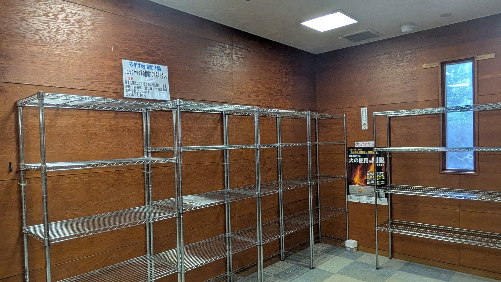 Wooden shelving for rucksacks inside the entrance of a bathhouse