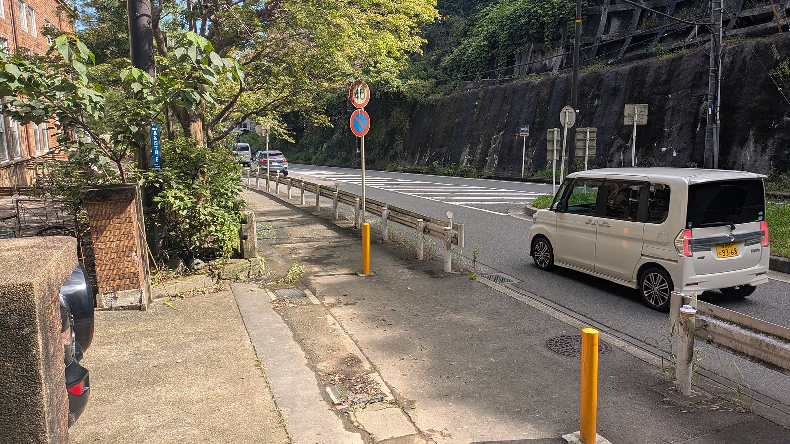 A road with retaining walls and a narrow pavement