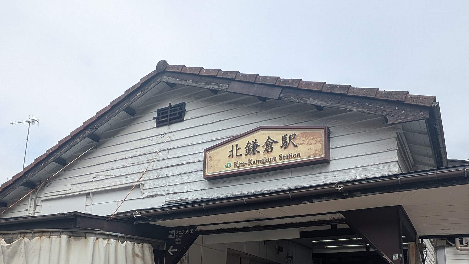 The wooden gable of Kita-Kamakura station with a name board in Japanese and English
