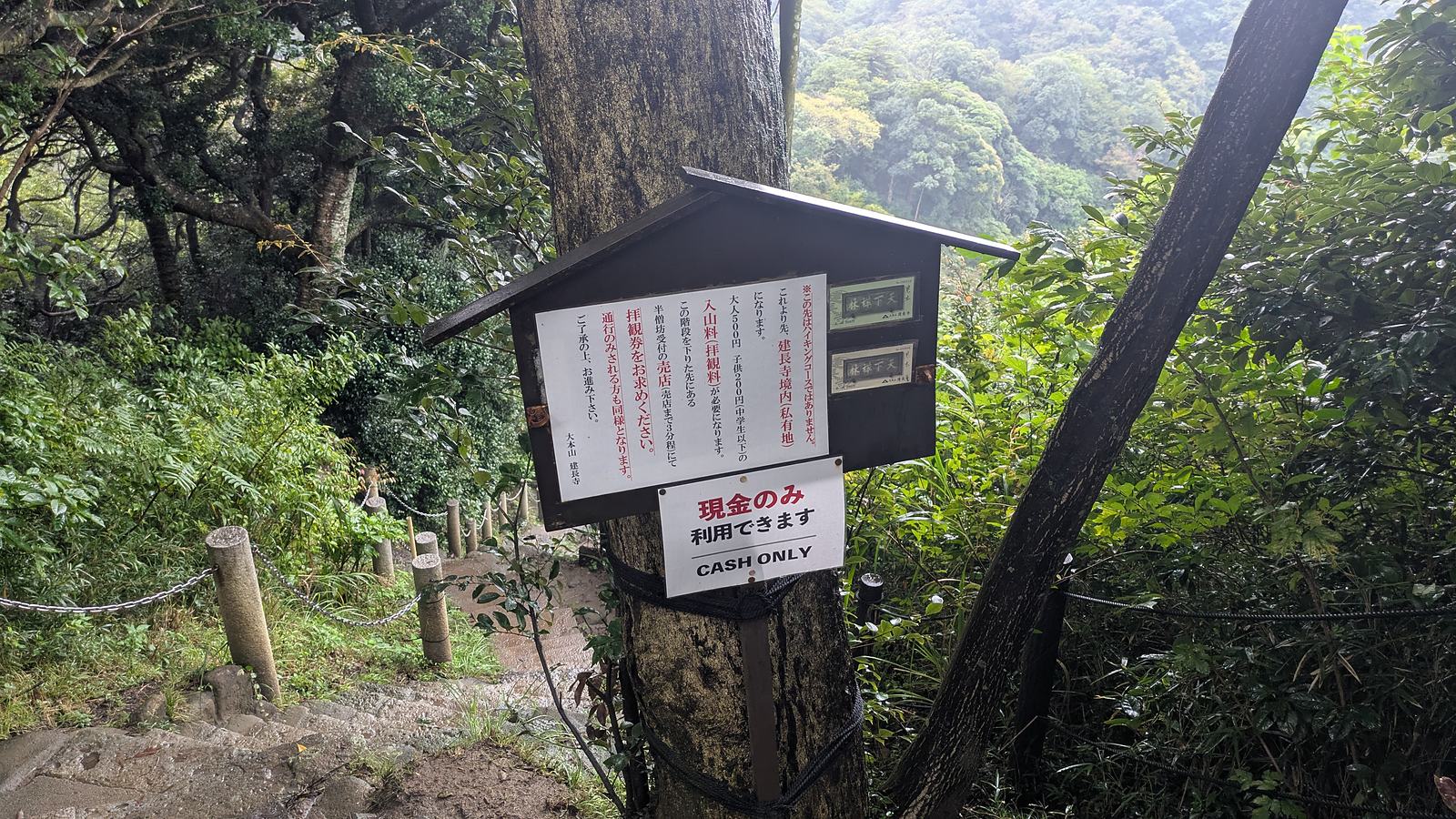 A notice board on the ridge above Hansobo with a second sign reading CASH ONLY