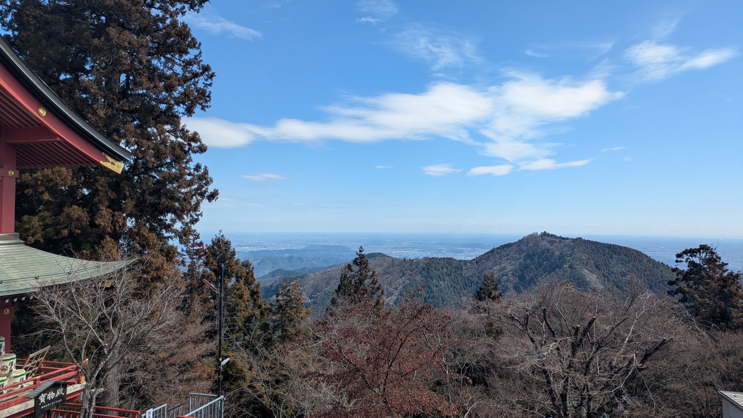 The red eave of Musashi Mitake Shrine at the left, with the Kanto plain opening out beyond the ridge