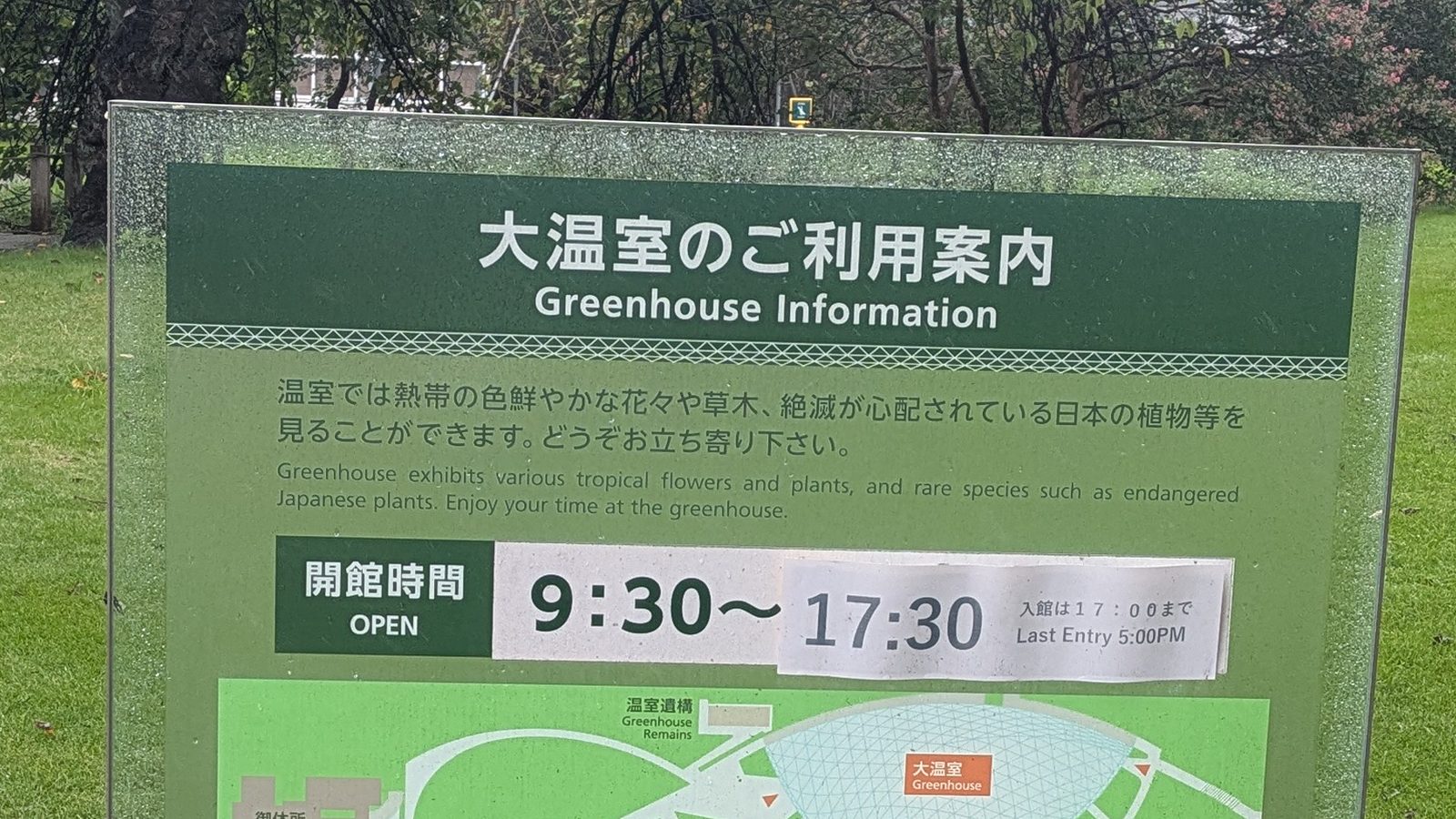 A bilingual board reading Greenhouse Information, open 9:30 to 17:30, last entry 5:00 PM, with a map