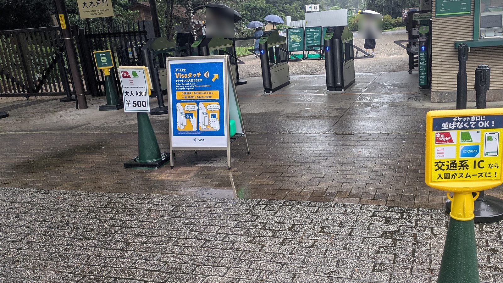 Entry turnstiles at Okido Gate with a yellow sign showing IC card logos and a blue sign for Visa contactless