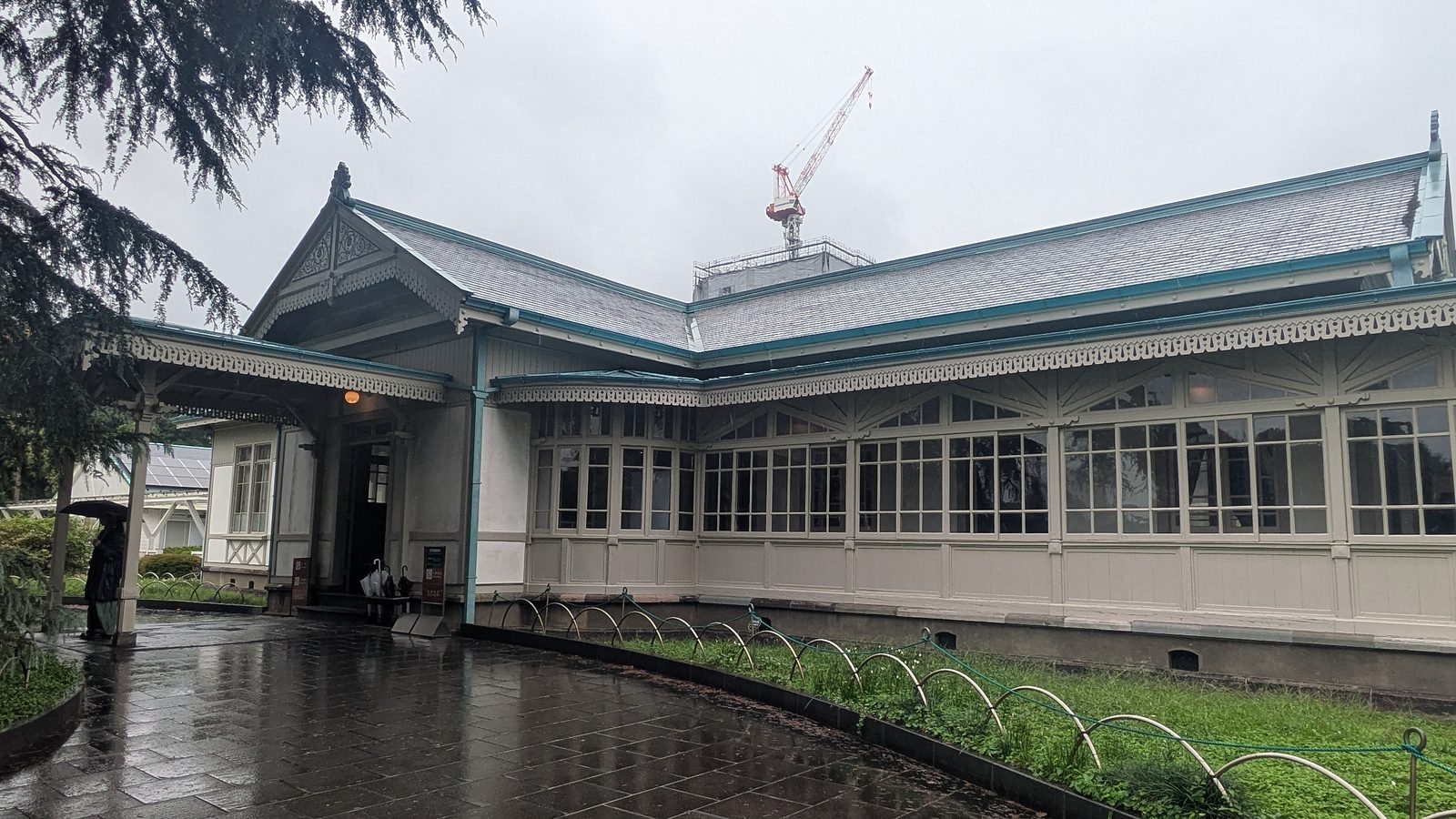 A single-storey Western-style wooden building with white window frames and a grey roof with teal trim