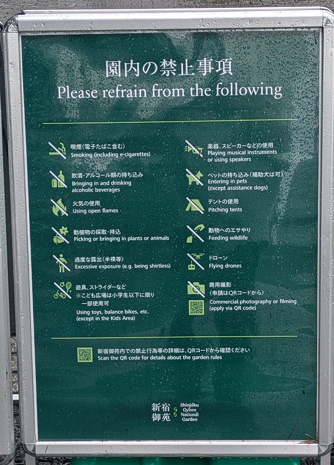 A green bilingual rules board showing twelve crossed-out icons, alcohol among them