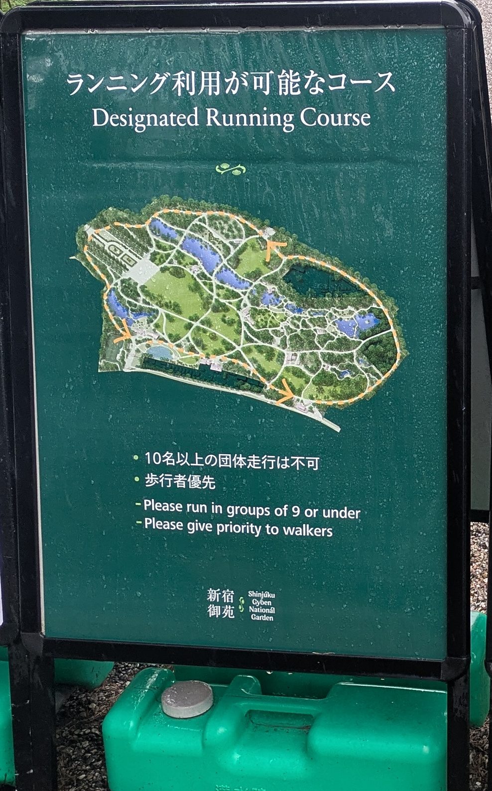 A green board with a map of the garden and an orange dotted loop marking the running course