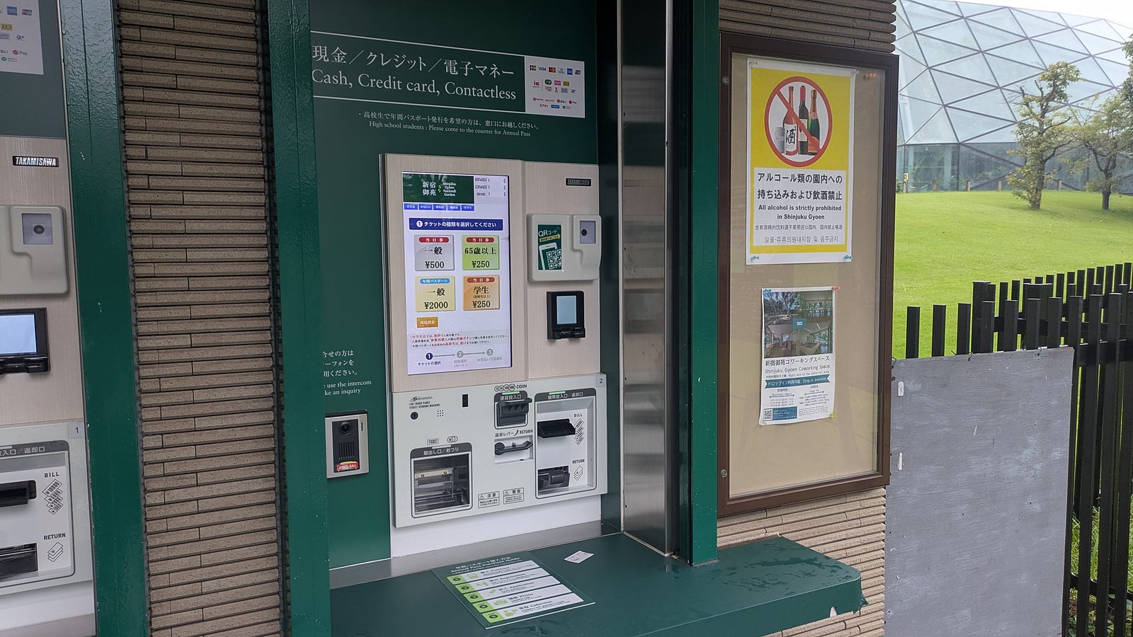 A ticket machine with a touch screen showing adult 500 yen, and a panel of card and QR payment logos above it